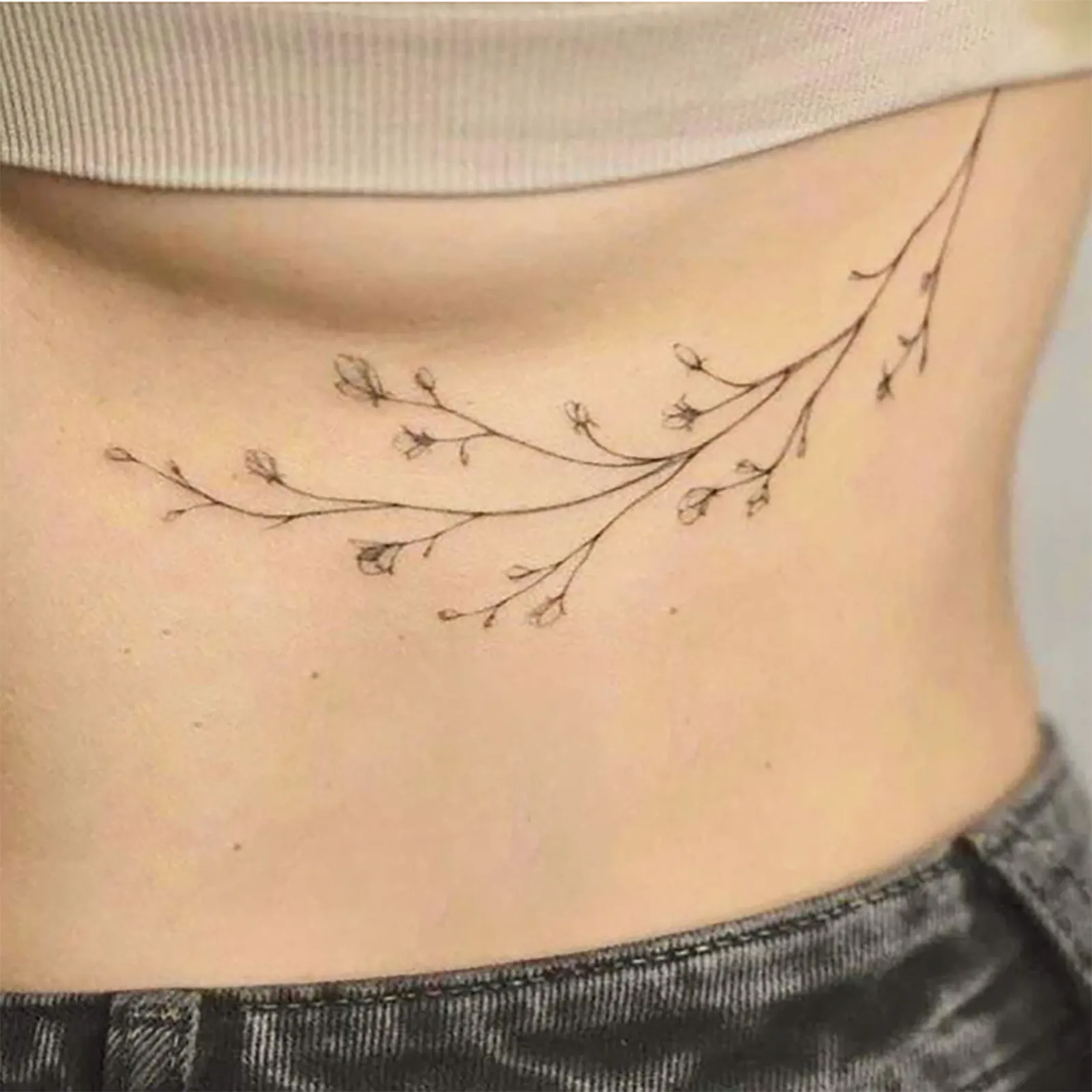 Celebrate Growth with This Delicate Branch & Bud Boho Tattoo