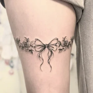 Add Elegant Charm with This Monochrome Rose & Bow Tattoo