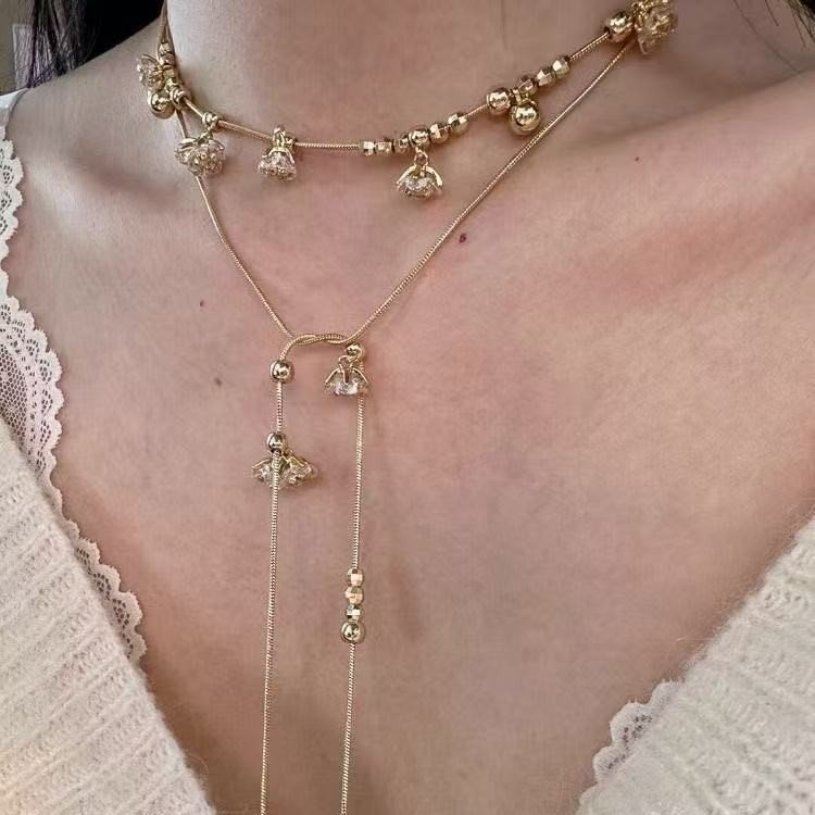 Long flower necklace with lily of the valley crystals. Wear long, double wrap as choker, or triple wrap as bracelet. Gold tone.