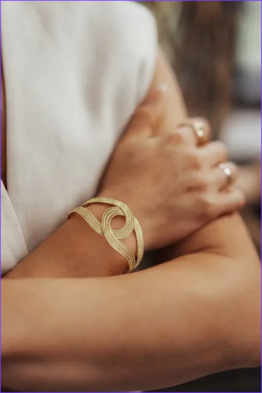Twisted braided bracelet in vintage old money gold. Adjustable open cuff with woven texture. 14K gold plated.